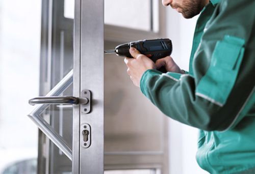 Commercial locksmith installing a lock on an office door